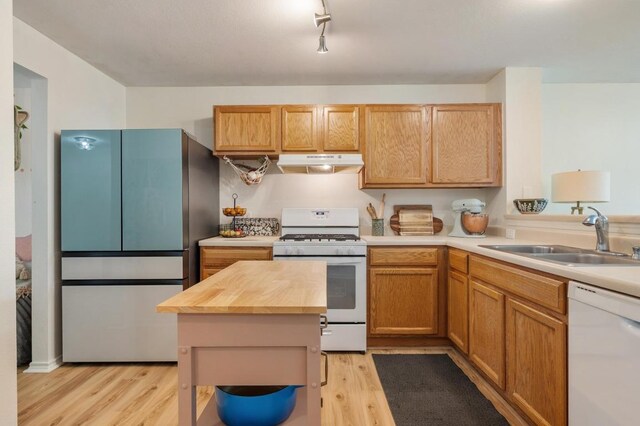 626 Goldenrod St, Kyle, TX 78640 - kitchen featuring white appliances, a sink, under cabinet range hood, light wood finished floors, and wooden counters