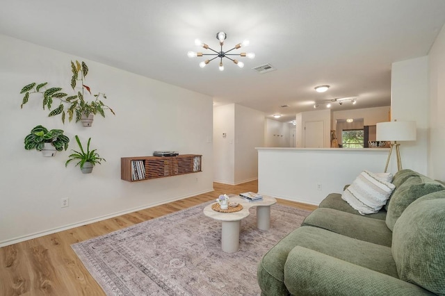 626 Goldenrod St, Kyle, TX 78640 - living area with a chandelier, light wood-style flooring, and baseboards