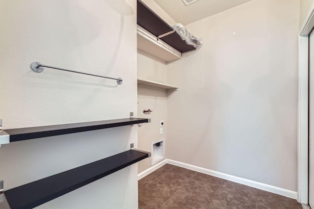 8521 White Ibis Dr, Austin, TX 78729 - laundry room with hookup for an electric dryer and dark tile patterned floors