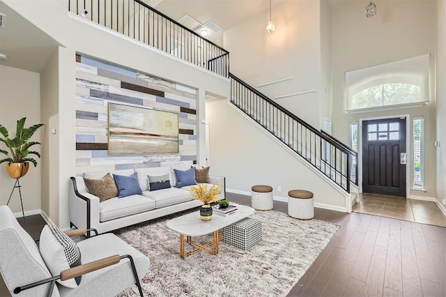 8521 White Ibis Dr, Austin, TX 78729 - living room featuring a towering ceiling, stairs, and wood finished floors