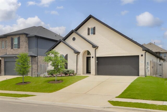 717 Sugar Cane Rd, Buda, TX 78610 - french country inspired facade featuring concrete driveway, an attached garage, and brick siding