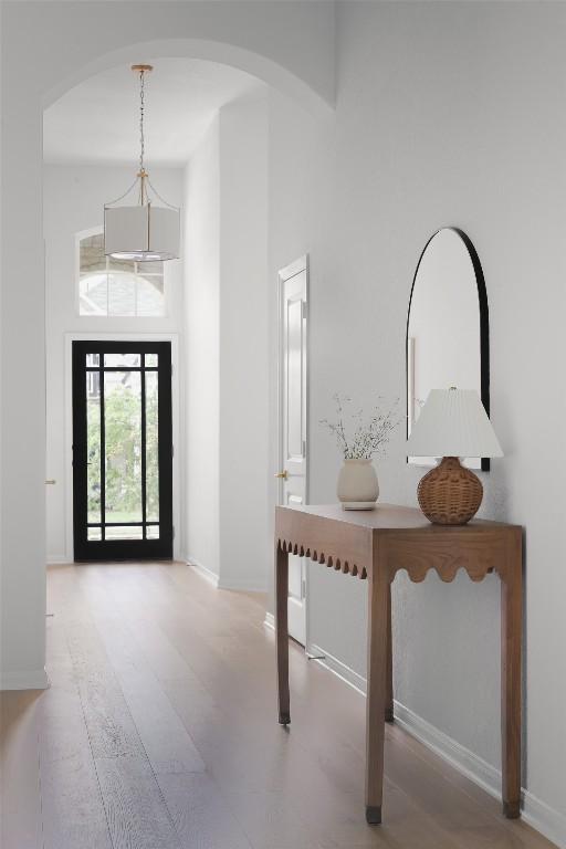 717 Sugar Cane Rd, Buda, TX 78610 - foyer with arched walkways, a high ceiling, baseboards, and wood finished floors