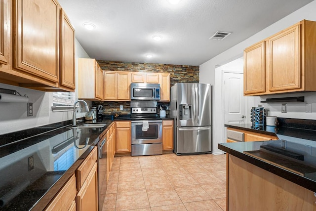 8936 Milton Lease Dr, Austin, TX 78747 - kitchen featuring appliances with stainless steel finishes, a sink, backsplash, light tile patterned floors, and light brown cabinetry