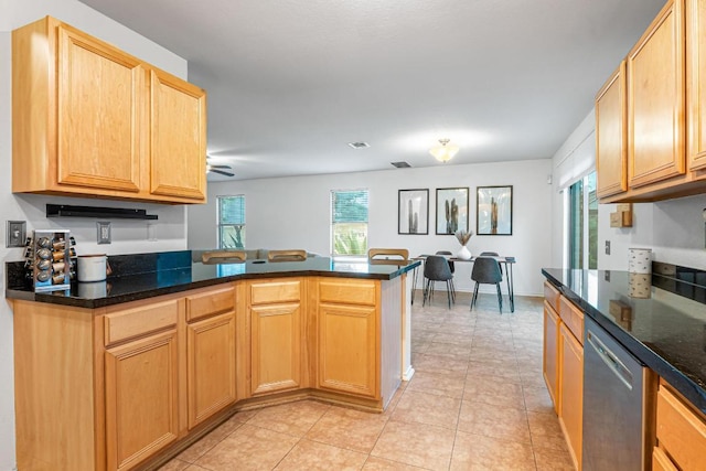 8936 Milton Lease Dr, Austin, TX 78747 - kitchen with dishwasher, light tile patterned floors, a peninsula, and dark stone countertops