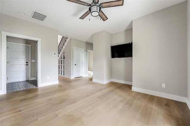 18700 Venture Dr, Point Venture, TX 78645 - unfurnished living room featuring ceiling fan, light wood-type flooring, and stairway