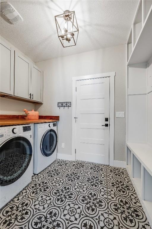 18700 Venture Dr, Point Venture, TX 78645 - washroom with separate washer and dryer, a textured ceiling, a chandelier, and cabinet space