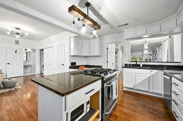 525 Barton Blvd, Austin, TX 78704 - kitchen featuring stainless steel appliances, dark wood-type flooring, white cabinets, and a kitchen island