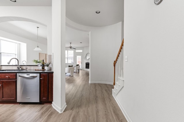 328 Palo Alto Way, Austin, TX 78732 - kitchen with dishwasher, light wood-style floors, dark countertops, arched walkways, and a sink