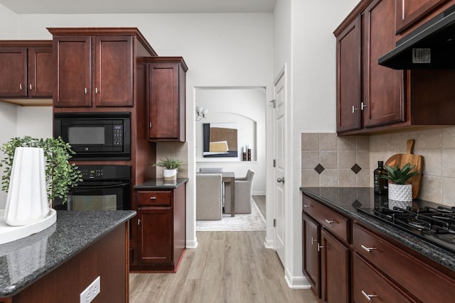 328 Palo Alto Way, Austin, TX 78732 - kitchen with under cabinet range hood, black appliances, light wood-style flooring, decorative backsplash, and dark stone countertops