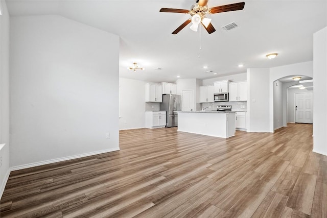 229 Reagor Dr, Taylor, TX 76574 - unfurnished living room with arched walkways, a ceiling fan, light wood-type flooring, recessed lighting, and baseboards