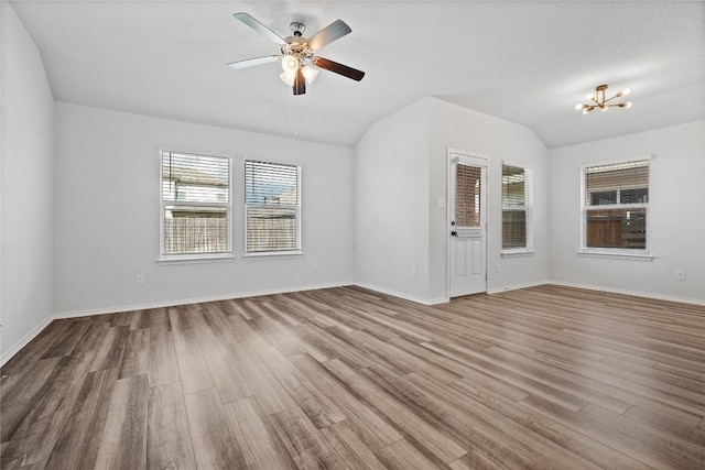 229 Reagor Dr, Taylor, TX 76574 - unfurnished room featuring wood finished floors, a ceiling fan, lofted ceiling, baseboards, and a chandelier