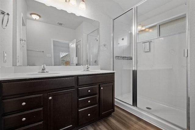 229 Reagor Dr, Taylor, TX 76574 - bathroom with double vanity, a stall shower, and wood finished floors