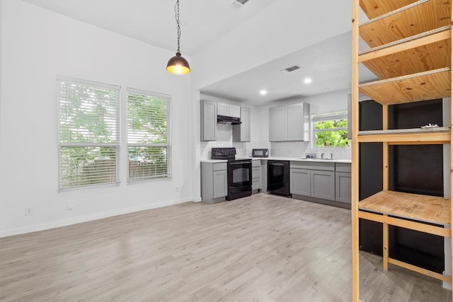 204 E Brenham St, Elgin, TX 78621 - kitchen with black appliances, gray cabinets, light countertops, decorative backsplash, and light wood-style flooring