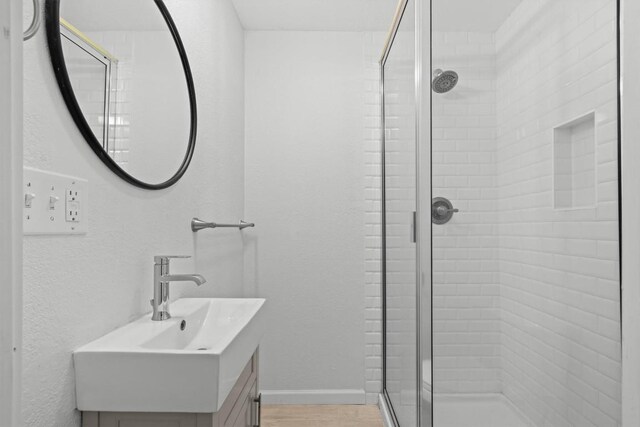 204 E Brenham St, Elgin, TX 78621 - full bathroom with a shower stall, vanity, and baseboards