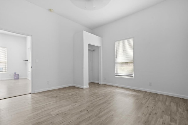 204 E Brenham St, Elgin, TX 78621 - unfurnished bedroom featuring multiple windows, wood finished floors, and baseboards