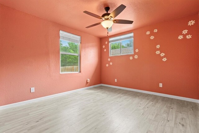 204 E Brenham St, Elgin, TX 78621 - unfurnished room with light wood finished floors, ceiling fan, baseboards, a textured ceiling, and a textured wall