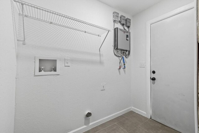 204 E Brenham St, Elgin, TX 78621 - laundry area with hookup for a washing machine, baseboards, dark tile patterned flooring, and hookup for an electric dryer