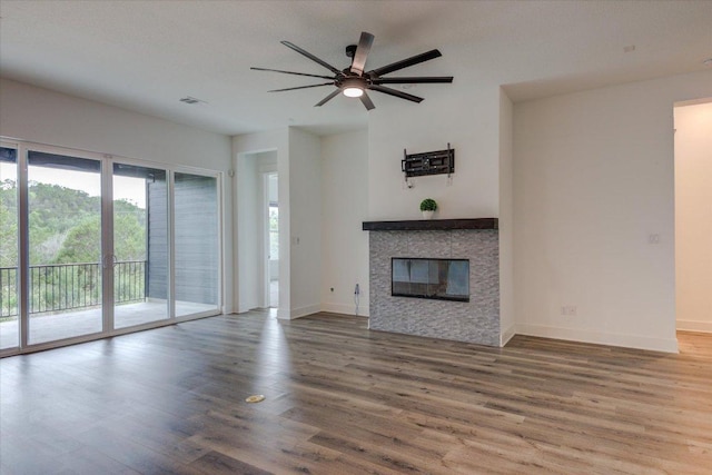 13401 Trail Driver, Austin, TX 78737 - unfurnished living room with healthy amount of natural light, a ceiling fan, a tile fireplace, and wood finished floors