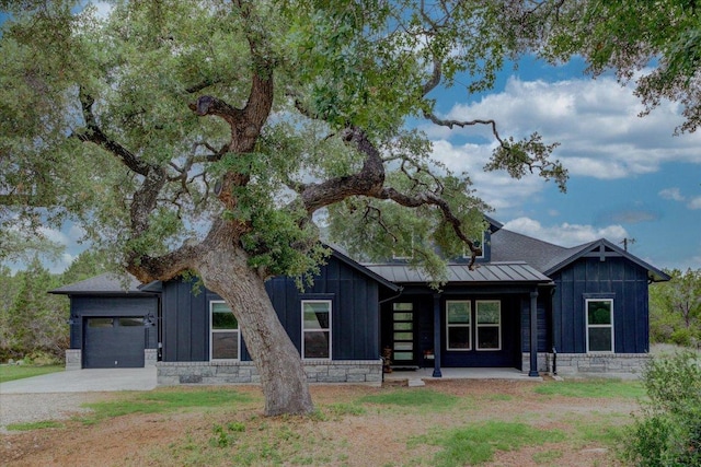13401 Trail Driver, Austin, TX 78737 - view of front of property featuring board and batten siding, stone siding, a standing seam roof, an attached garage, and driveway