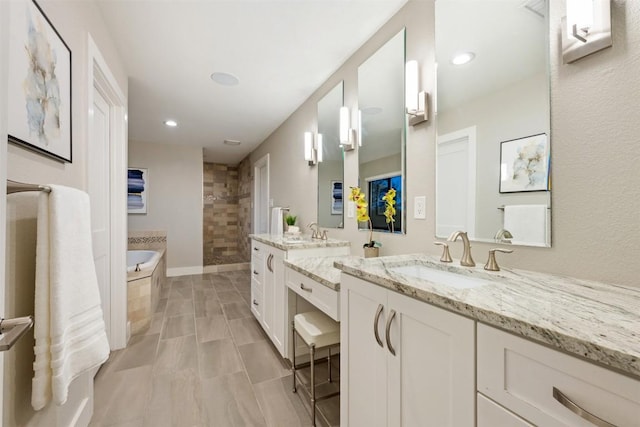 19407 White Horse Cv, Spicewood, TX 78669 - bathroom featuring two vanities, a bath, tiled shower, and recessed lighting