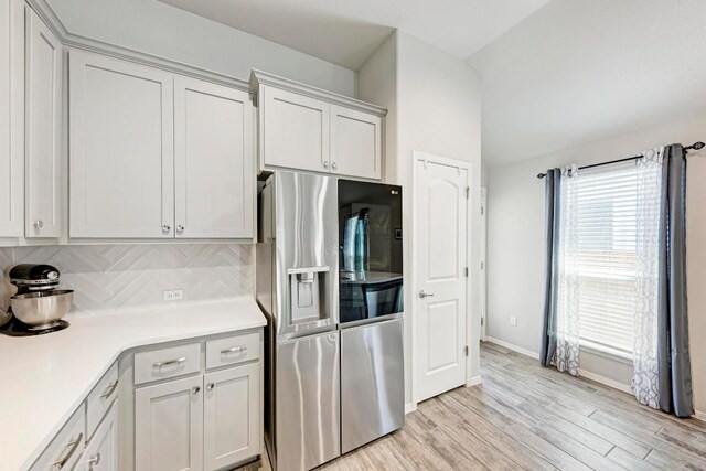 133 Free Stone Dr, Georgetown, TX 78628 - kitchen with stainless steel refrigerator with ice dispenser, light countertops, tasteful backsplash, light wood finished floors, and baseboards