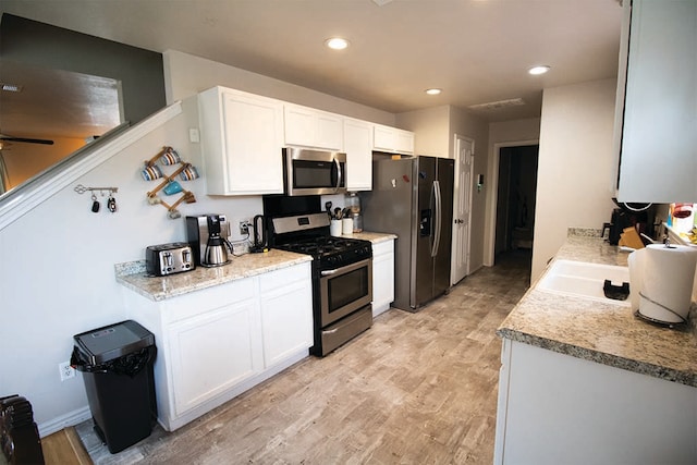 2723 Moonmist Cv, Round Rock, TX 78665 - kitchen with appliances with stainless steel finishes, light wood-style flooring, white cabinets, light countertops, and recessed lighting