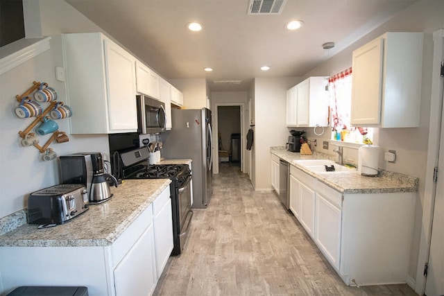 2723 Moonmist Cv, Round Rock, TX 78665 - kitchen featuring stainless steel appliances, light wood-style flooring, white cabinetry, light countertops, and recessed lighting
