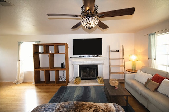 2723 Moonmist Cv, Round Rock, TX 78665 - living area featuring a ceiling fan, wood finished floors, and a fireplace with raised hearth