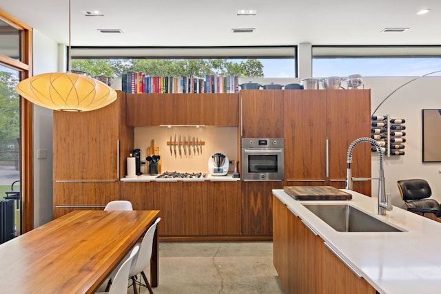 6506 Arroyo Seco, Austin, TX 78757 - kitchen featuring a sink, stainless steel oven, brown cabinetry, light countertops, and modern cabinets