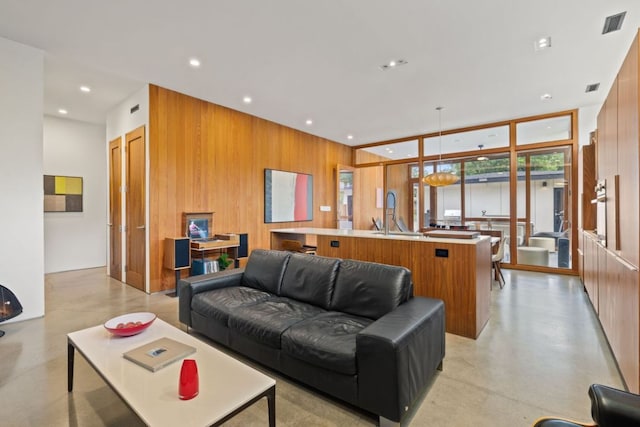 6506 Arroyo Seco, Austin, TX 78757 - living area featuring concrete floors, wooden walls, and recessed lighting
