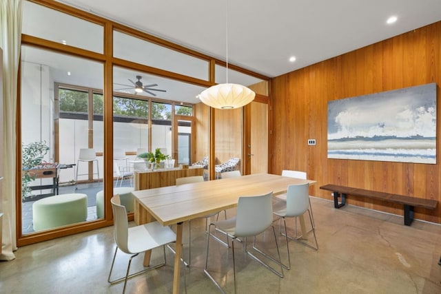 6506 Arroyo Seco, Austin, TX 78757 - dining room with concrete flooring, wooden walls, a ceiling fan, and recessed lighting