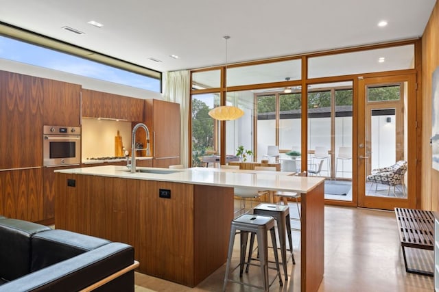 6506 Arroyo Seco, Austin, TX 78757 - kitchen with stainless steel oven, a sink, brown cabinetry, light countertops, and modern cabinets