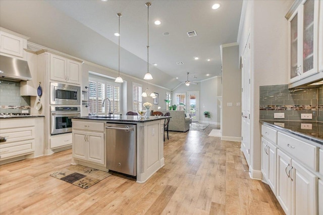 2416 Montello Ct, Leander, TX 78641 - kitchen featuring appliances with stainless steel finishes, tasteful backsplash, open floor plan, a ceiling fan, and vaulted ceiling
