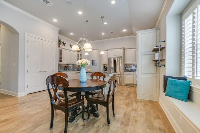 2416 Montello Ct, Leander, TX 78641 - dining room with crown molding, arched walkways, light wood-style flooring, and recessed lighting