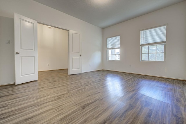 102 George Kimble Cv, Bastrop, TX 78602 - unfurnished bedroom featuring wood finished floors and baseboards