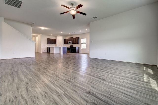 102 George Kimble Cv, Bastrop, TX 78602 - unfurnished living room with a ceiling fan, wood finished floors, recessed lighting, and baseboards