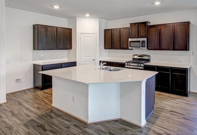 102 George Kimble Cv, Bastrop, TX 78602 - kitchen featuring appliances with stainless steel finishes, a sink, wood finished floors, backsplash, and recessed lighting