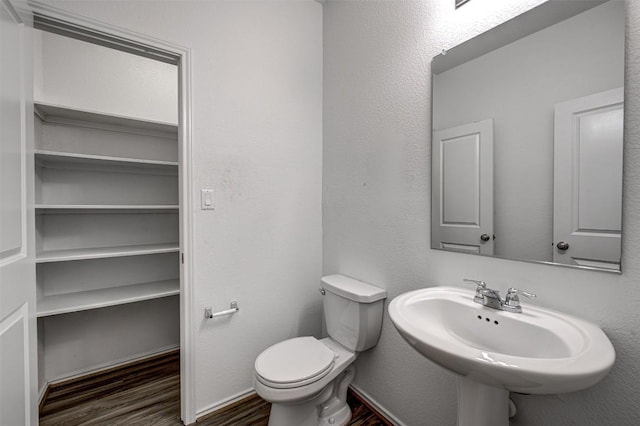 102 George Kimble Cv, Bastrop, TX 78602 - half bathroom with wood finished floors, toilet, and a sink