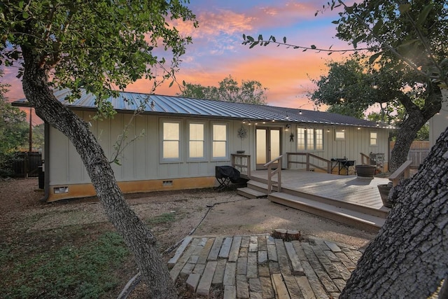 5604 Hudson Bend Rd, Austin, TX 78734 - back of house at dusk featuring crawl space, board and batten siding, metal roof, and a deck