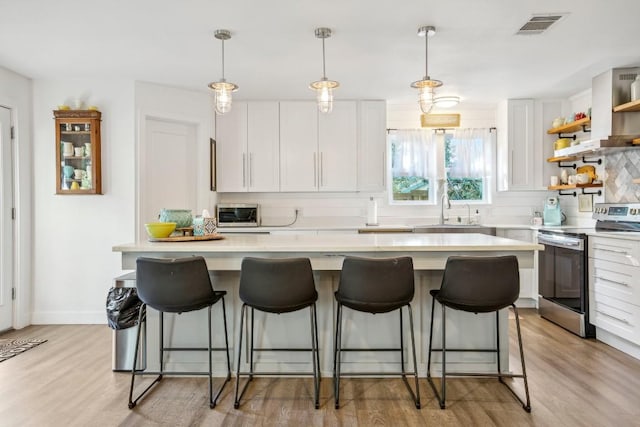 5604 Hudson Bend Rd, Austin, TX 78734 - kitchen featuring electric range, a sink, tasteful backsplash, light countertops, and light wood-style floors