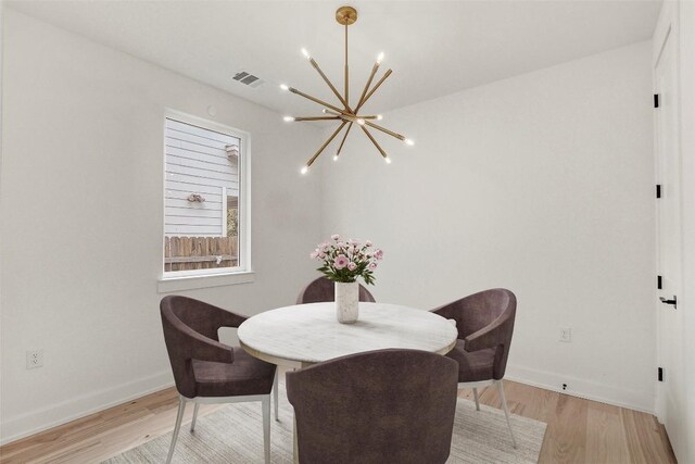 4127 E 12th St Unit 8, Austin, TX 78721 - dining space featuring a chandelier, light wood finished floors, and baseboards