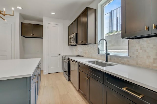 4127 E 12th St Unit 8, Austin, TX 78721 - kitchen featuring a sink, stainless steel appliances, light wood-style floors, backsplash, and recessed lighting