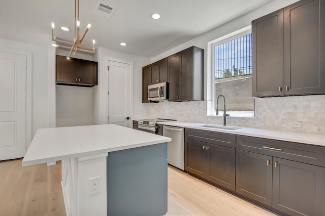 4127 E 12th St Unit 8, Austin, TX 78721 - kitchen featuring stainless steel appliances, a sink, backsplash, a chandelier, and recessed lighting