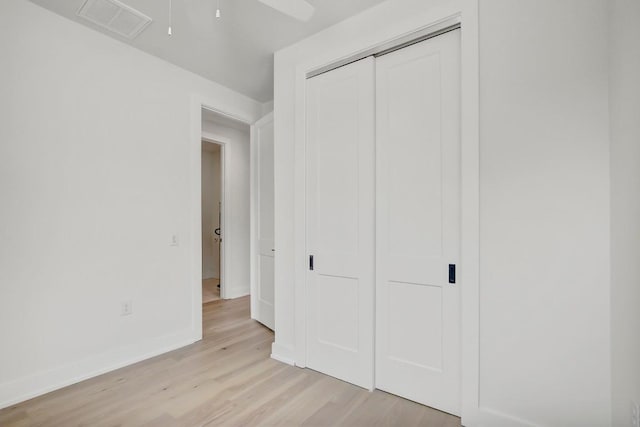 4127 E 12th St Unit 8, Austin, TX 78721 - unfurnished bedroom with light wood finished floors, baseboards, a closet, and ceiling fan