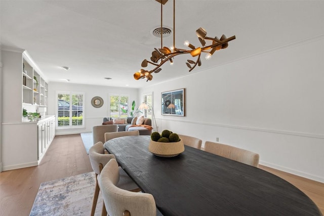 4607 Balcones Dr, Austin, TX 78731 - dining area with a chandelier, light wood-type flooring, and crown molding