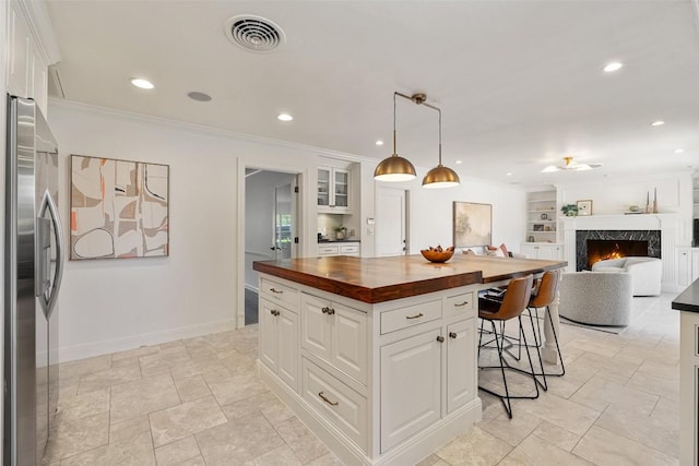 4607 Balcones Dr, Austin, TX 78731 - kitchen featuring wooden counters, stainless steel fridge, a kitchen bar, a center island, and a high end fireplace