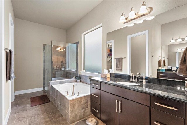 21912 Rock Wren Rd, Spicewood, TX 78669 - bathroom featuring a bath, vanity, a shower stall, and baseboards