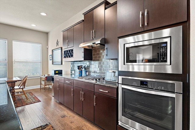 21912 Rock Wren Rd, Spicewood, TX 78669 - kitchen with stainless steel appliances, baseboards, light wood finished floors, tasteful backsplash, and recessed lighting