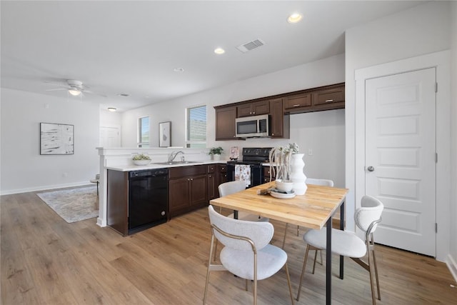 129 Syrah Ct, Leander, TX 78641 - kitchen featuring black appliances, a sink, dark brown cabinets, a peninsula, and light countertops