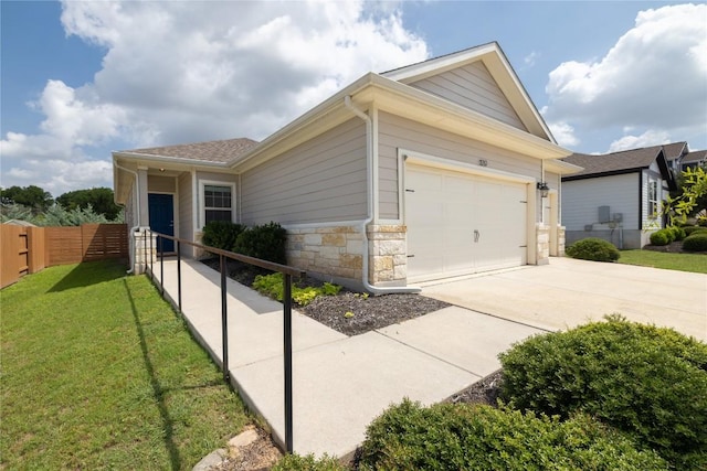 129 Syrah Ct, Leander, TX 78641 - view of side of home with concrete driveway, stone siding, an attached garage, and roof with shingles